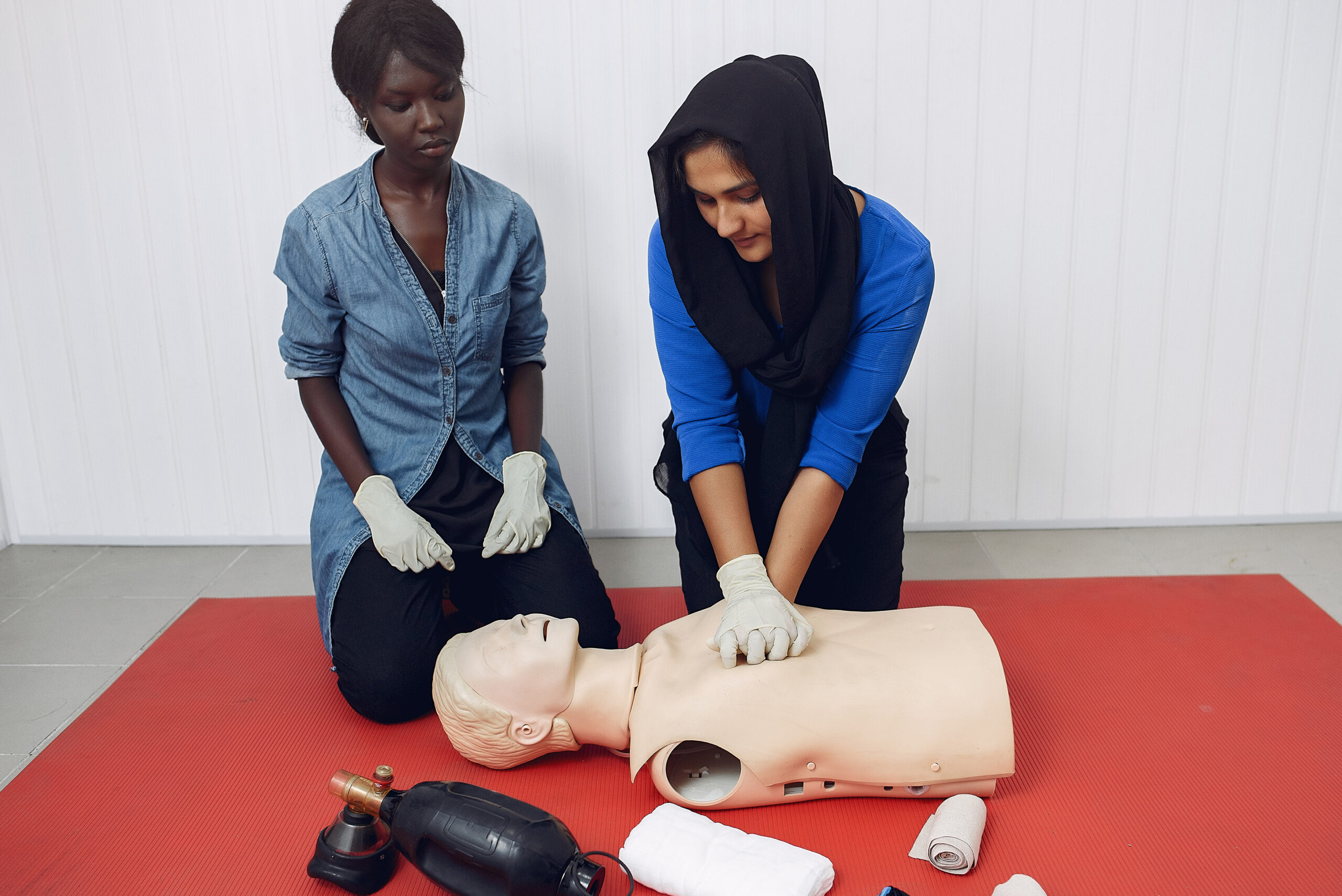 Woman learns to do artificial respiration on a mannequin - First Aid In The Workplace | Franklins Training Services